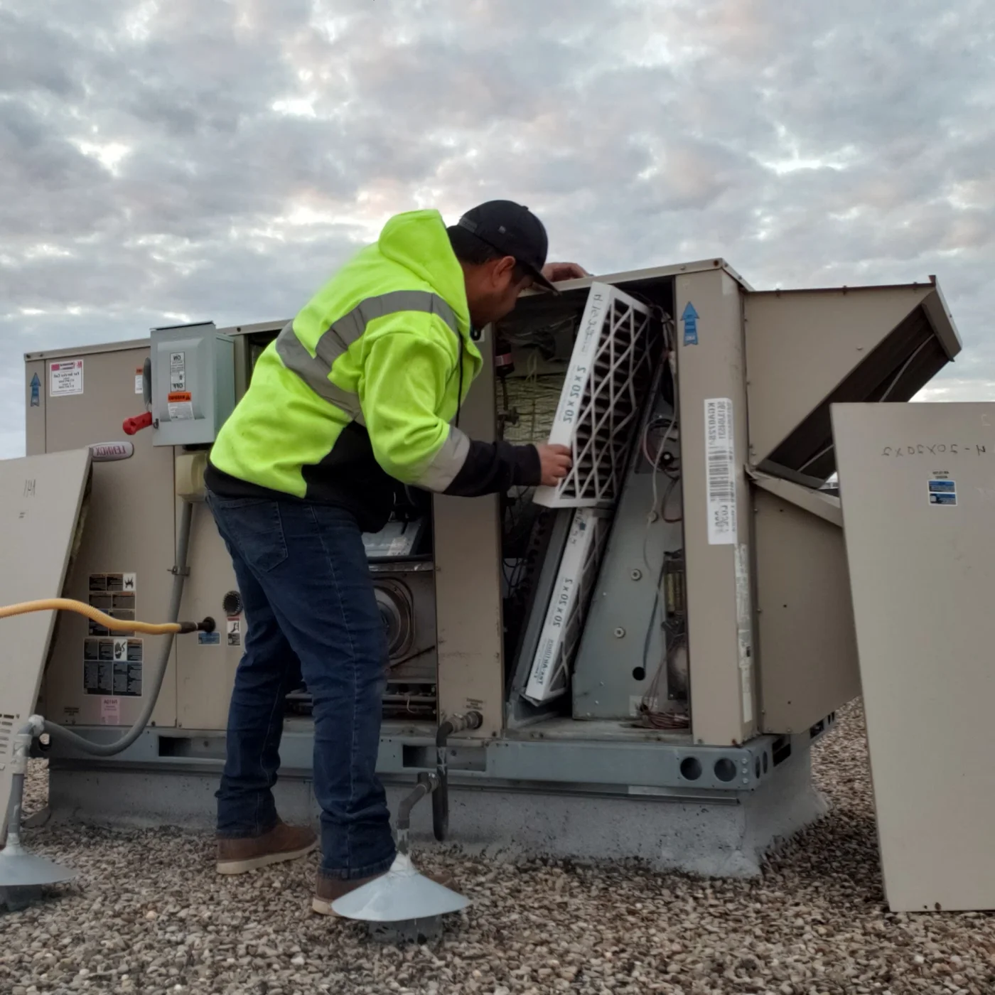 HVAC technician inspecting a rooftop air conditioning unit